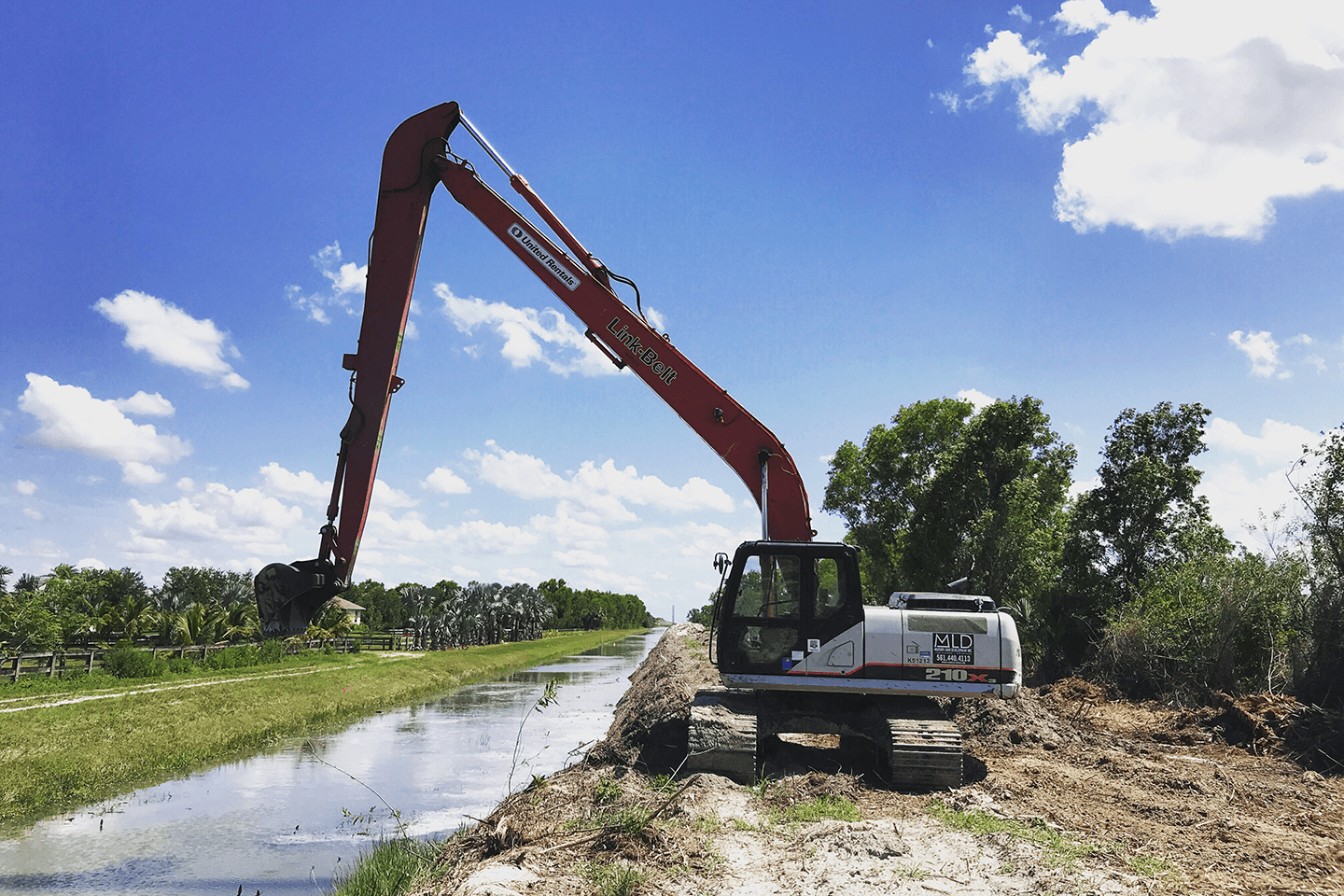 Excavator preparing to dig dirt out of a canal